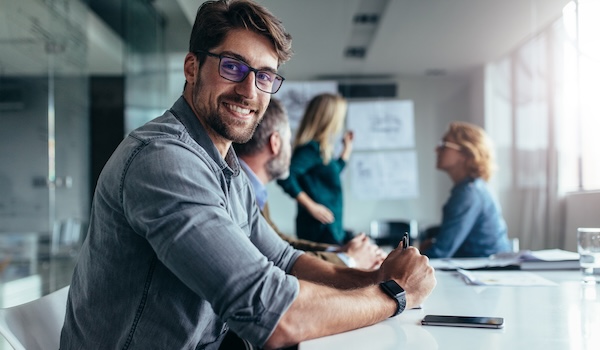 man in glasses in office smiling