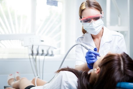dental hygienist treating patient